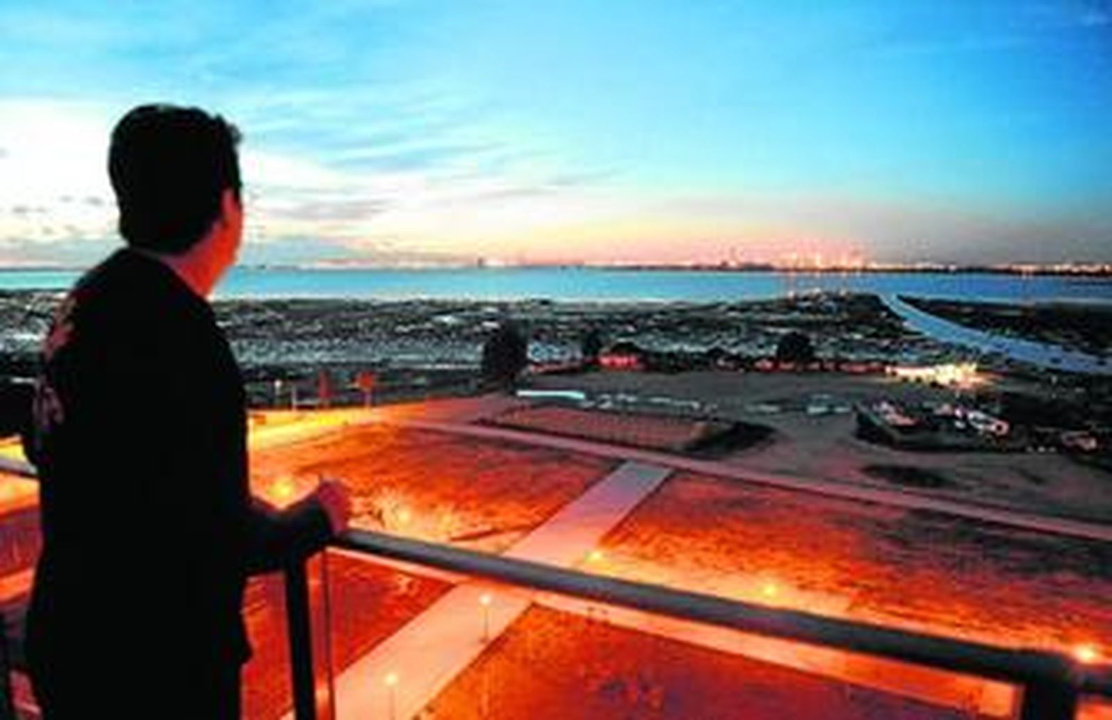 Vista de la Bahía de Cádiz desde la terraza de un piso de la novena planta de la torre central de La Casería, con su inquilina observando el paisaje.