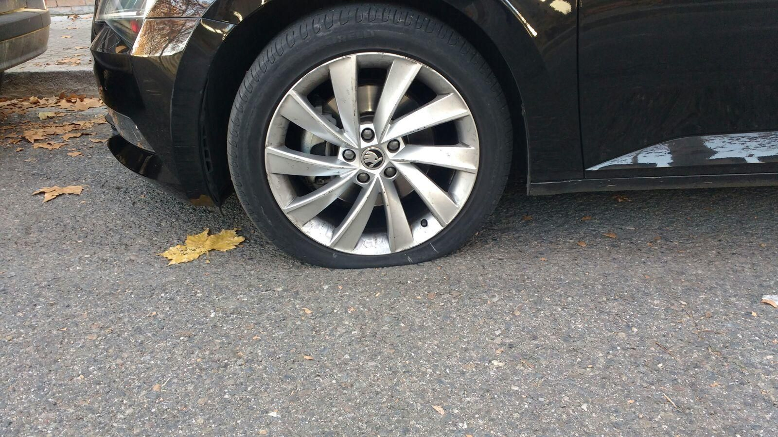 El coche con la rueda pinchada.