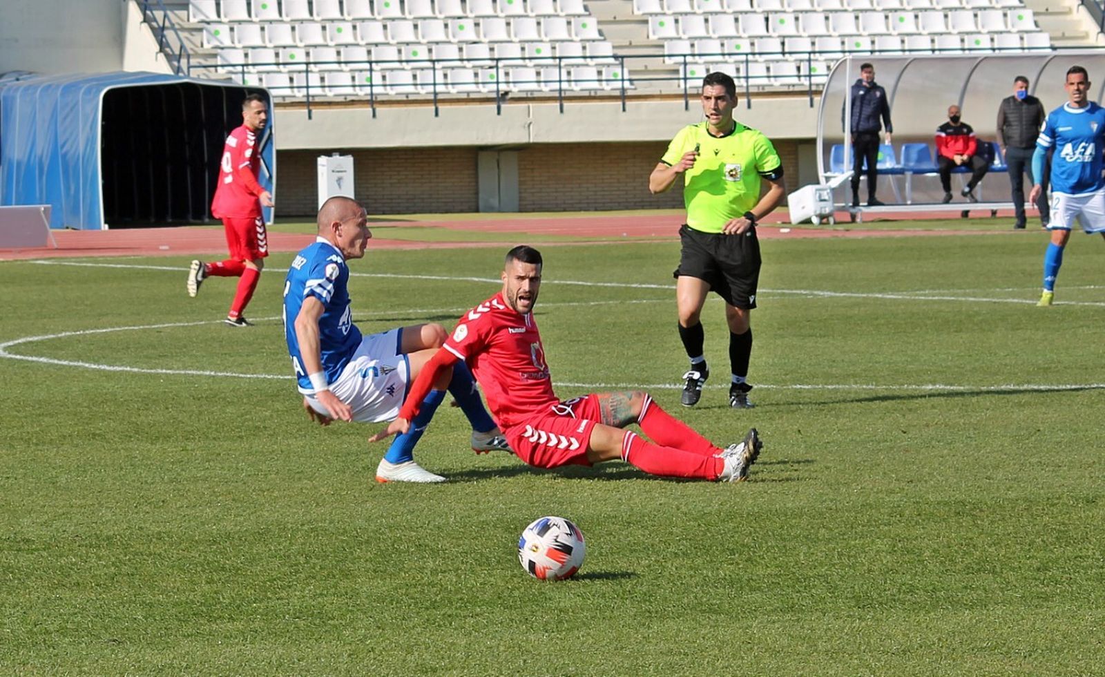 Lolo González y un jugador del Tamaraceite caen ante un balón dividido.