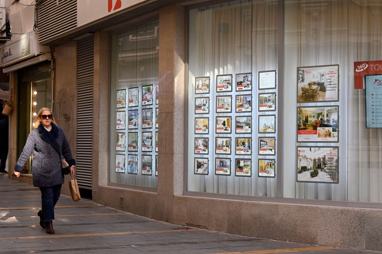 Una mujer pasa delante de una inmobiliaria de Córdoba.