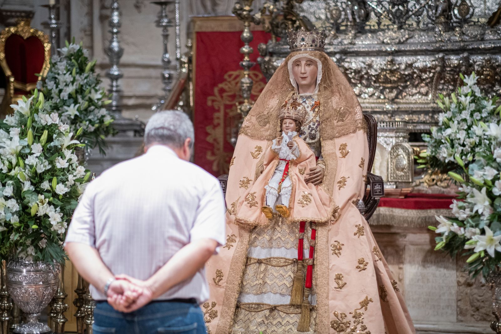 Un devoto se inclina ante la Virgen de los Reyes
