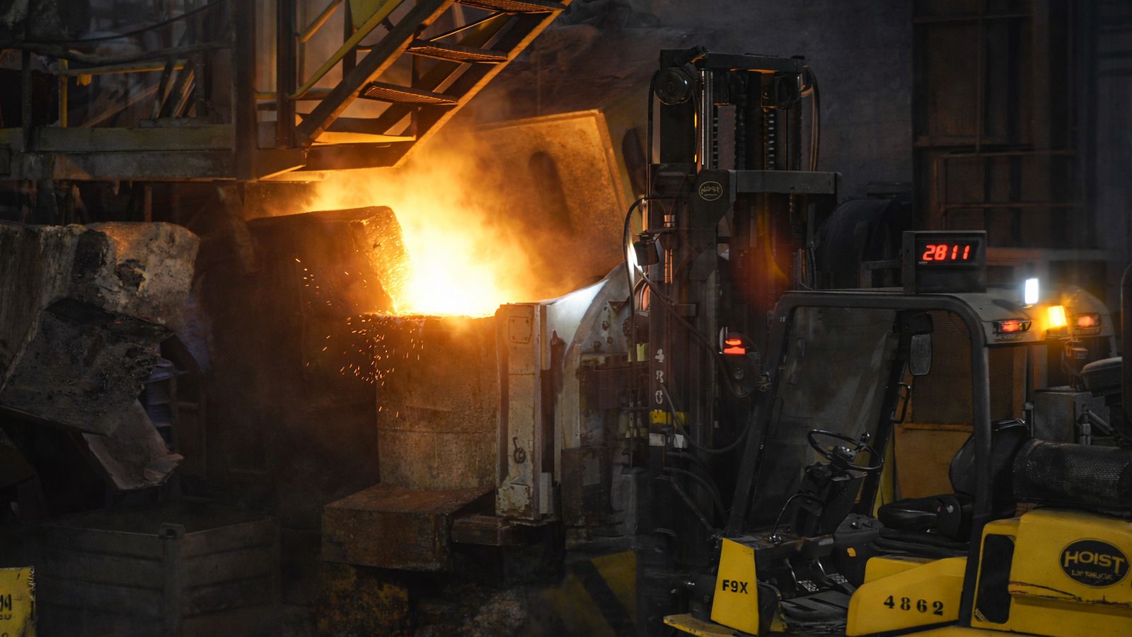 Las carretillas elevaladoras se suceden al pie del cilindro metálico del cubilote, que funciona como una gran barbacoa, para retirar el hierro fundido que llevarán a las líneas de moldeo.