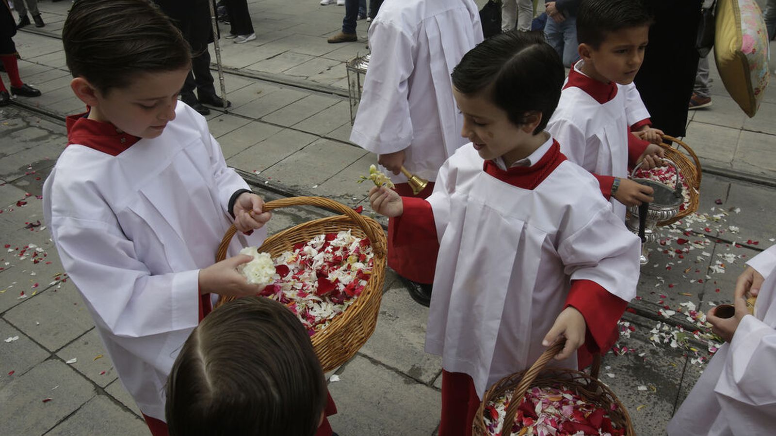 Los niños carráncanos alfombran la ciudad con pétalos de flores