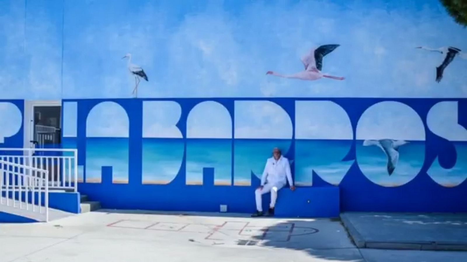 El autor posa ante su obra en el centro educativo.