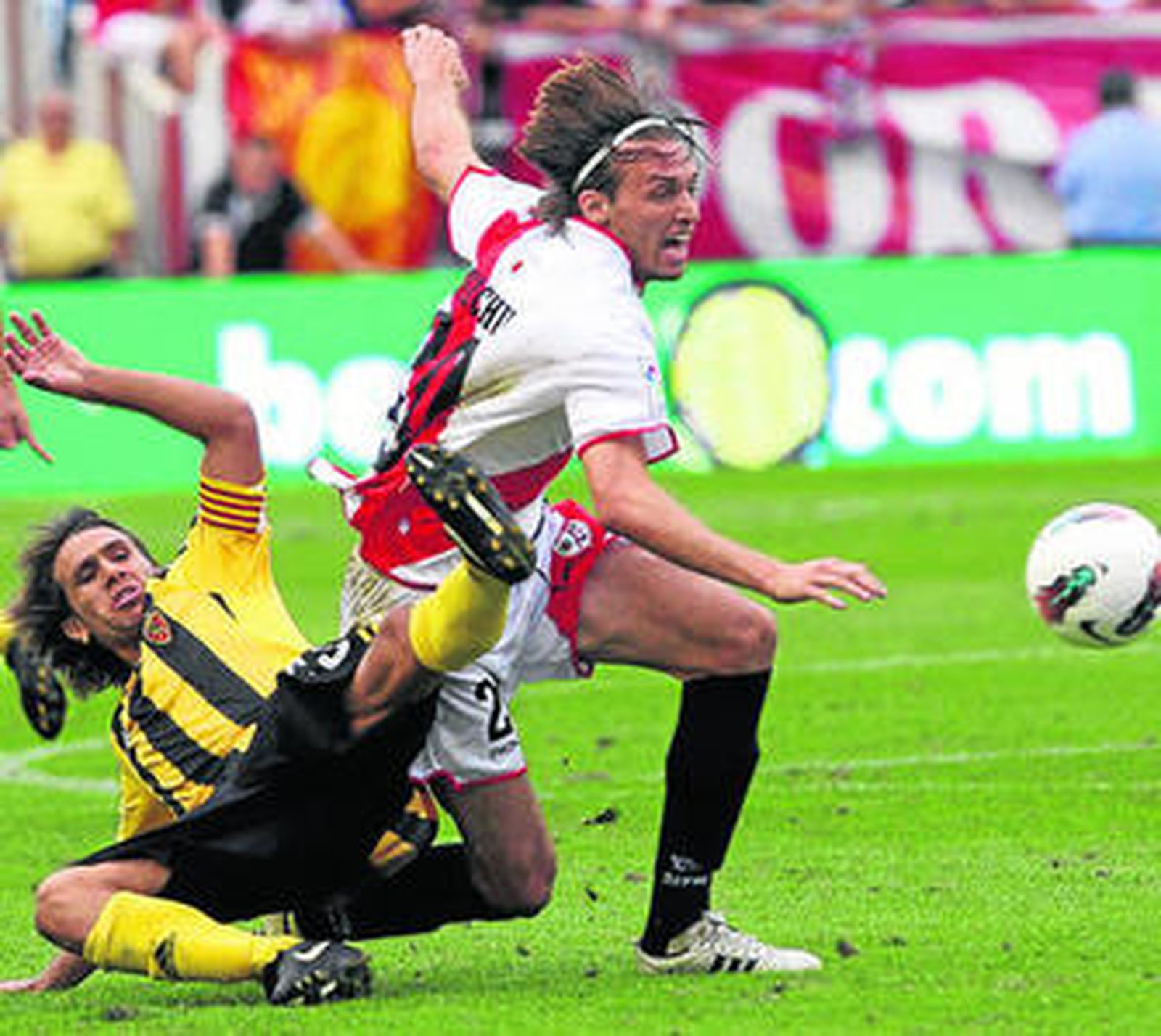 El rayista Michu se intenta llevar el balón ante Ponzio.