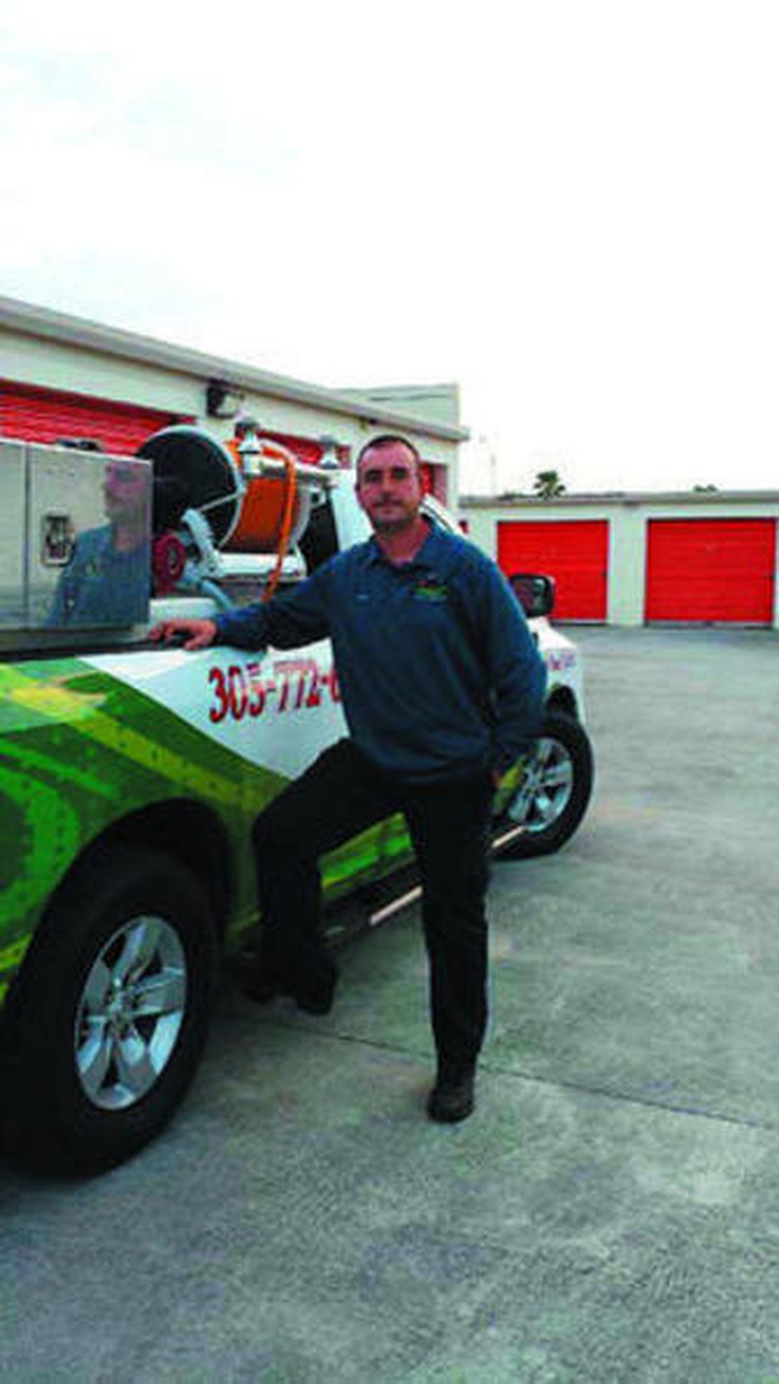 García Moyano, junto a uno de los vehículos de su empresa de jardinería.