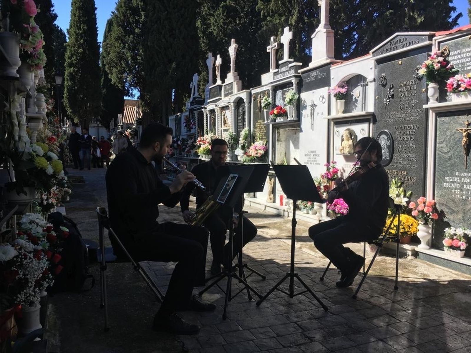 Un pequeño grupo de música toca en el cementerio de Cúllar Vega
