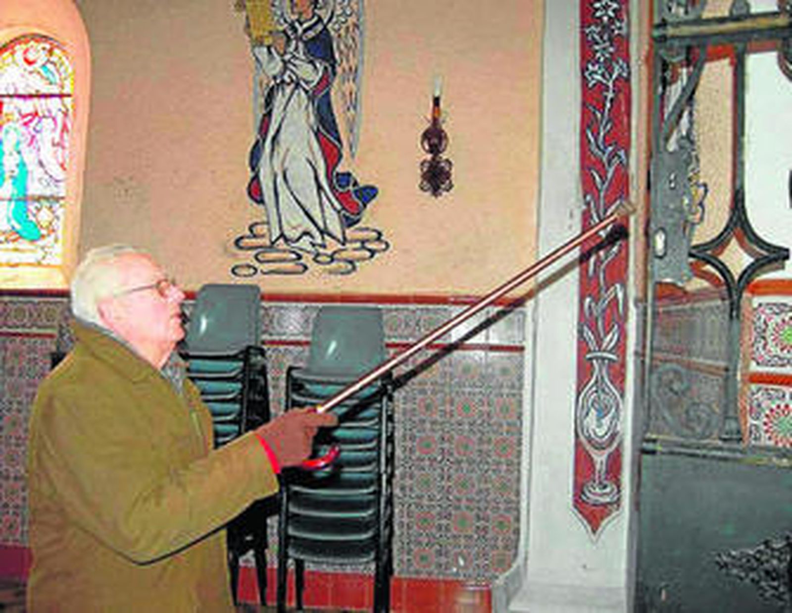 Un miembro de la hermandad señala los daños.