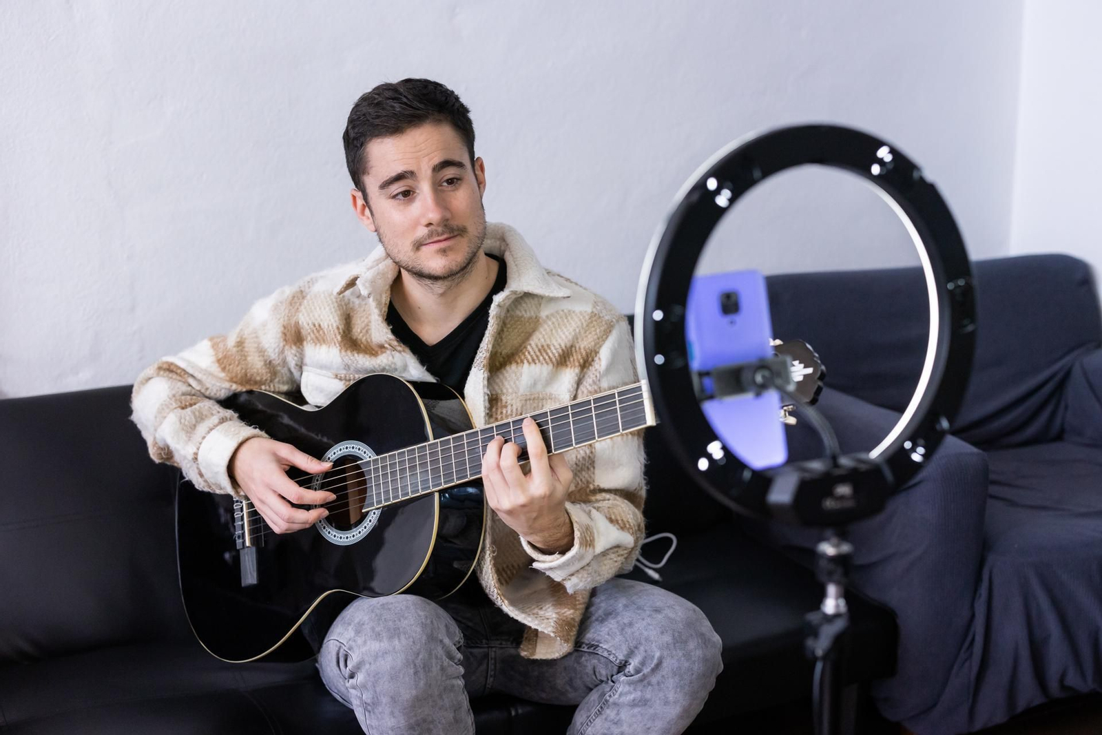 Adrián Campos, junto a su guitarra, grabándose para Tik Tok.