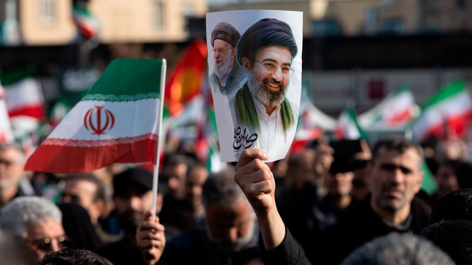Un hombre sujeta un cartel con la imagen del nuevo líder supremo de Irán, Mojtaba  Jamenei