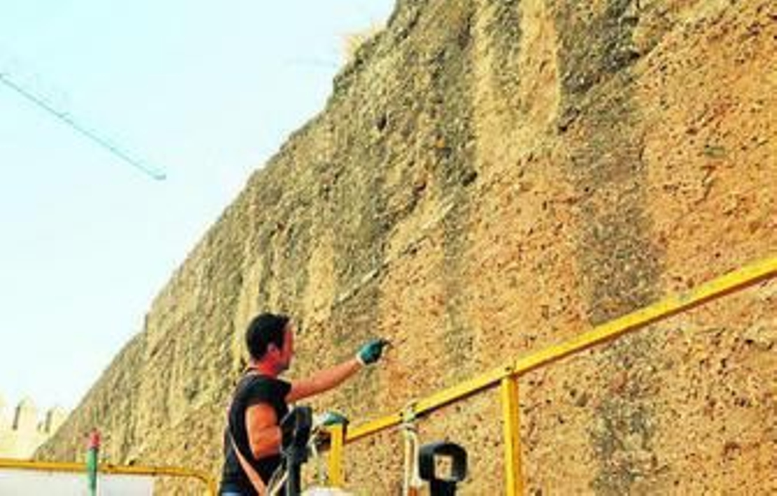 Uno de los restauradores trabajando en un lienzo de la muralla.