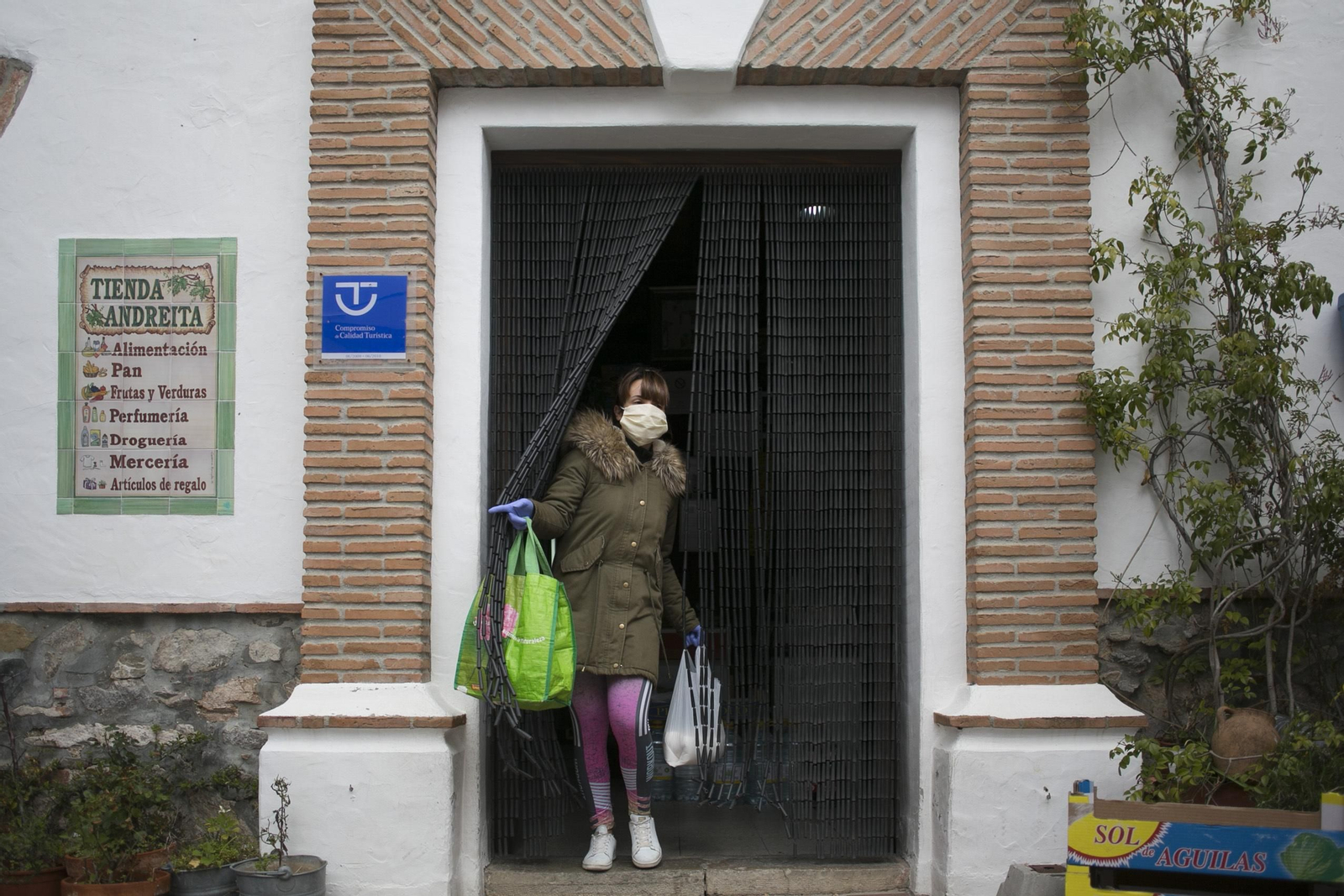 Vecina sale de una de las tiendas de Benarrabá tras realizar las compras.