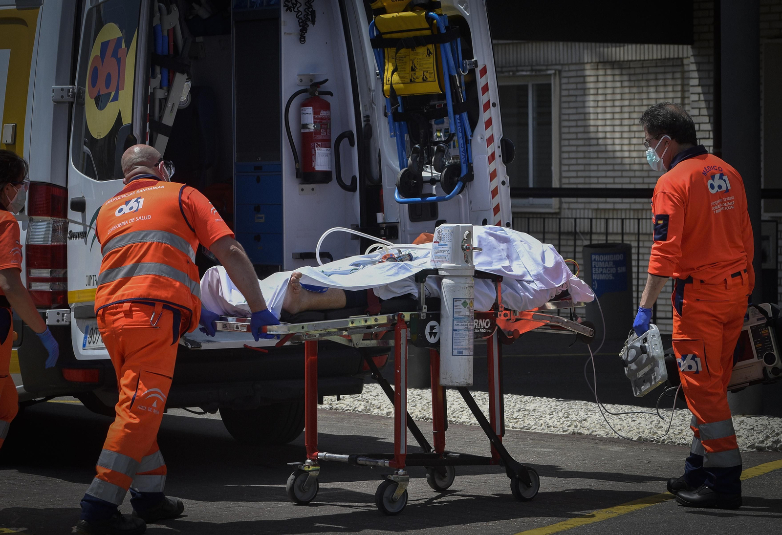 Dos sanitarios del 061 trasladan a un enfermo a un centro hospitalario.