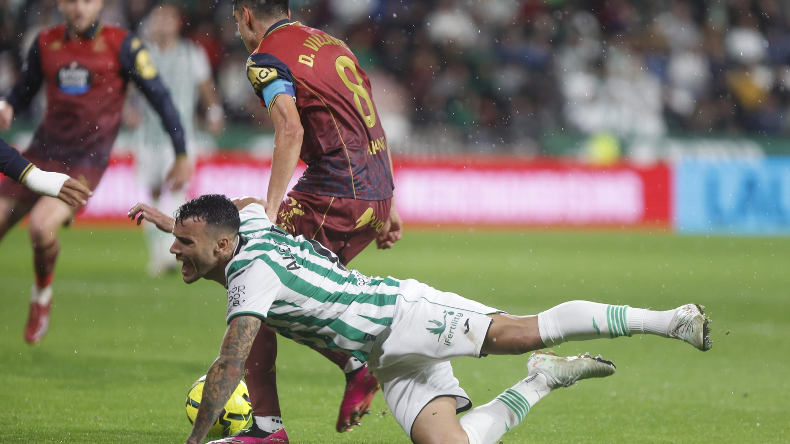 Álex Martín es derribado por Diego Villares en un lance del Córdoba CF - Deportivo de La Coruña.