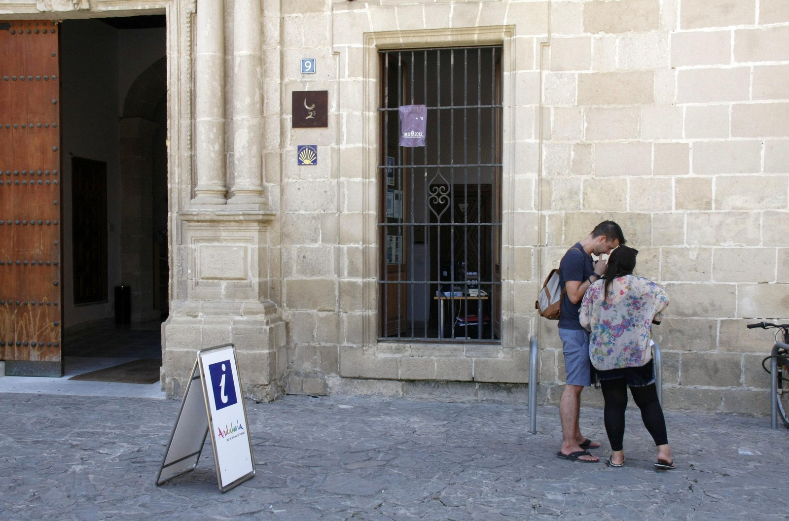 Una pareja, consultando un mapa ante la oficina de Turismo de El Puerto.