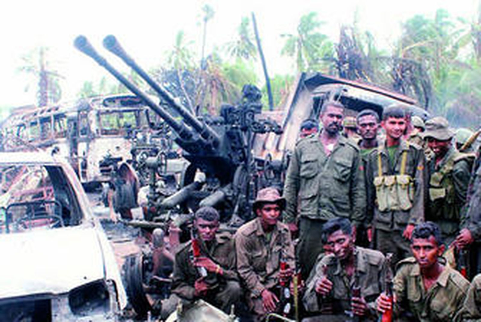 Soldados ceilaneses posan con sus armas en un escenario de destrucción tras el final de los enfrentamientos con los Tigres Tamiles.