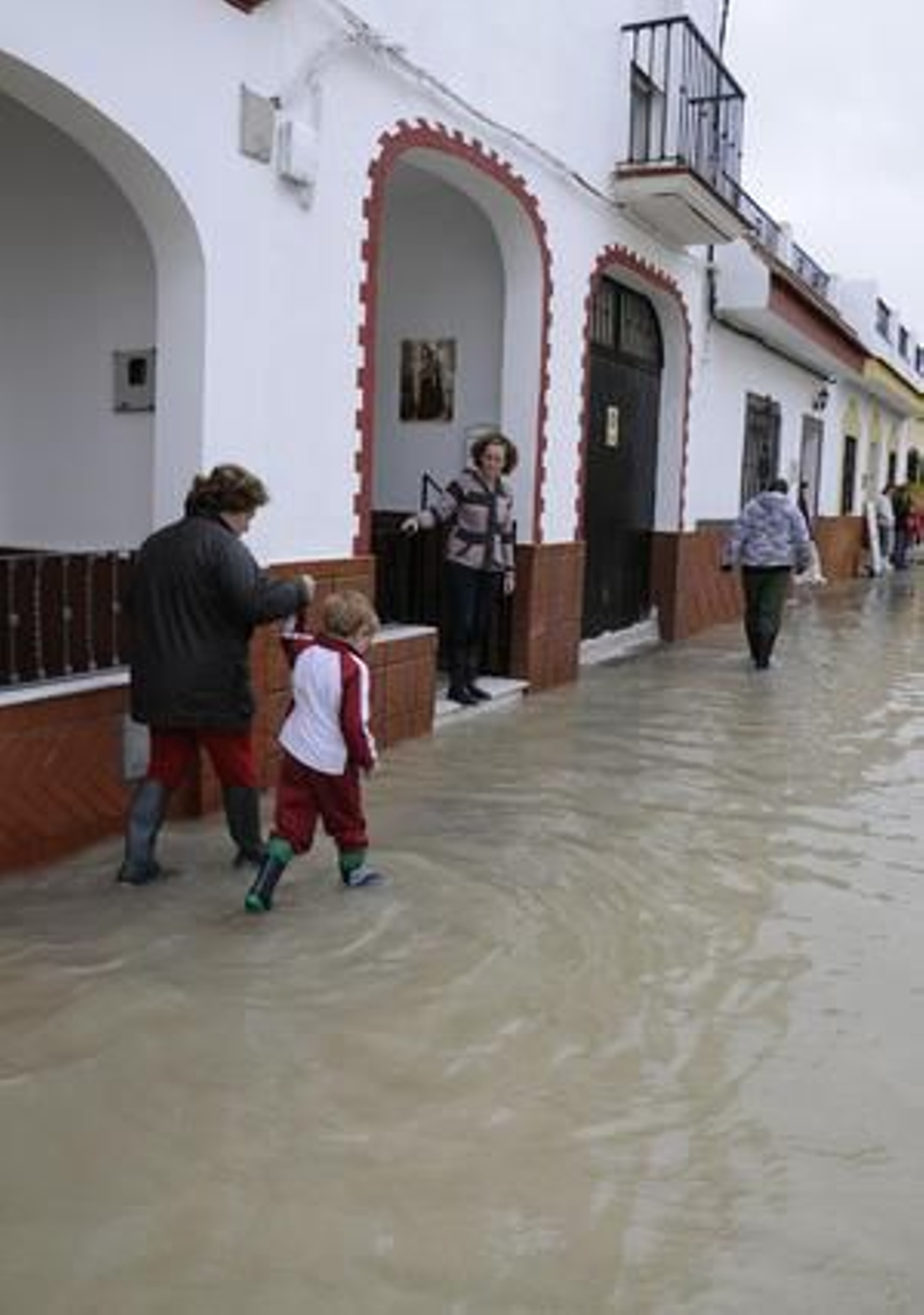 Una mujer anda con un niño de la mano por una calle de Tocina cubierta por el agua.

Foto: Juan Carlos Vázquez
