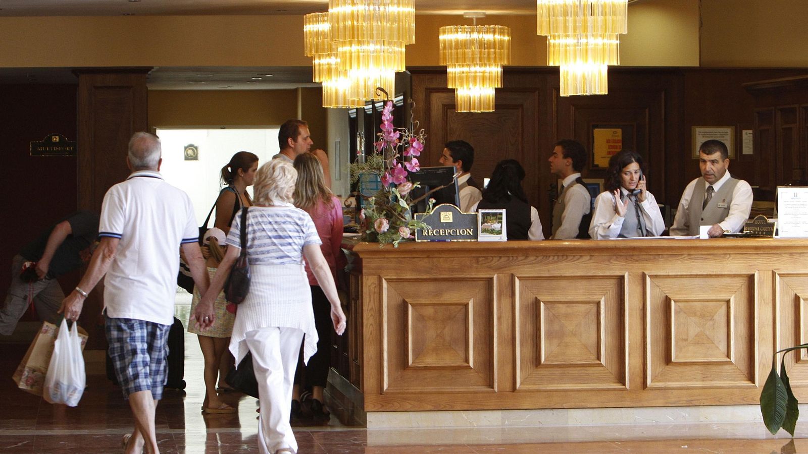 Unos clientes en la recepción de un hotel.