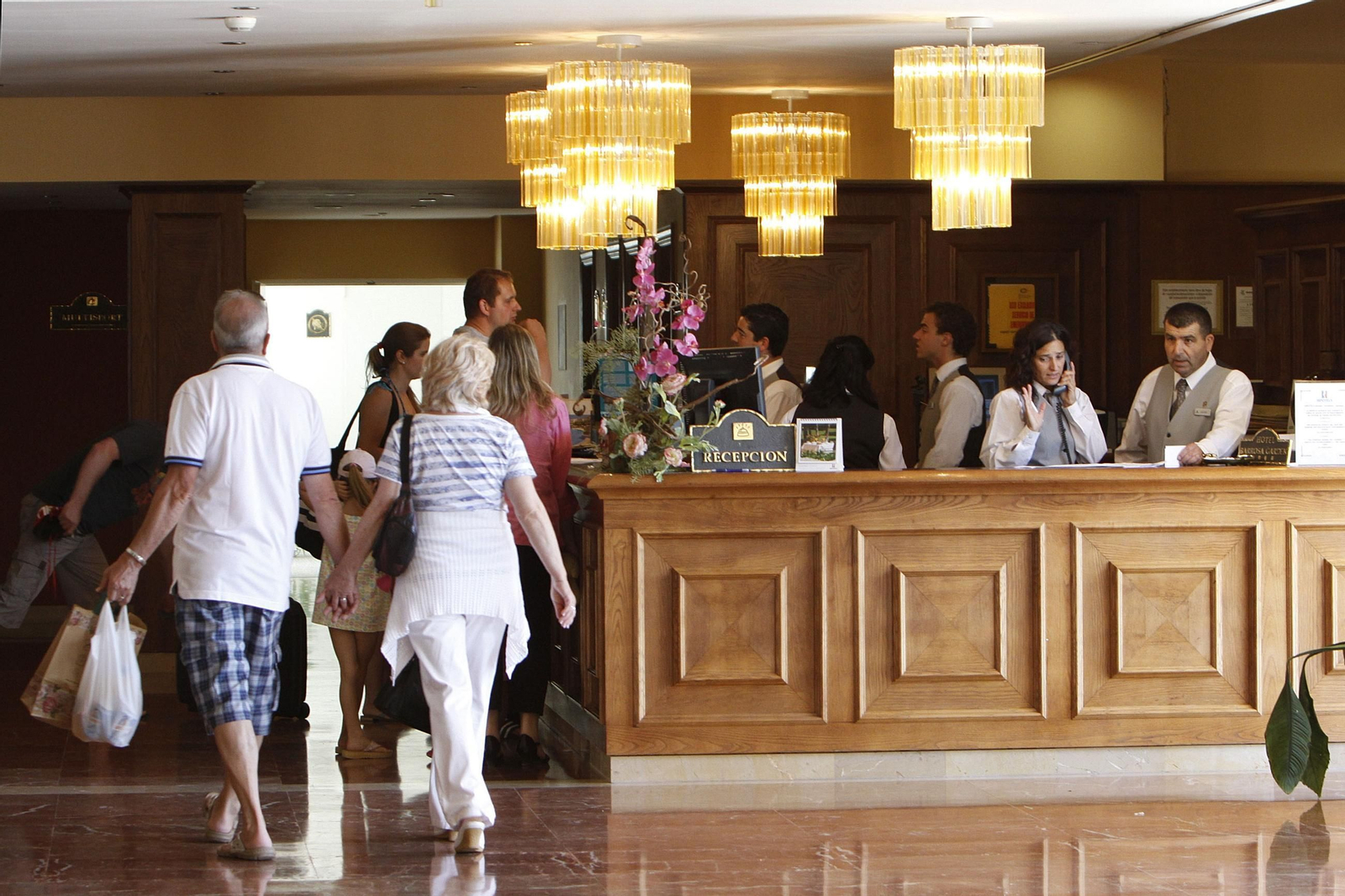 Unos clientes en la recepción de un hotel. Unos clientes en la recepción de un hotel.