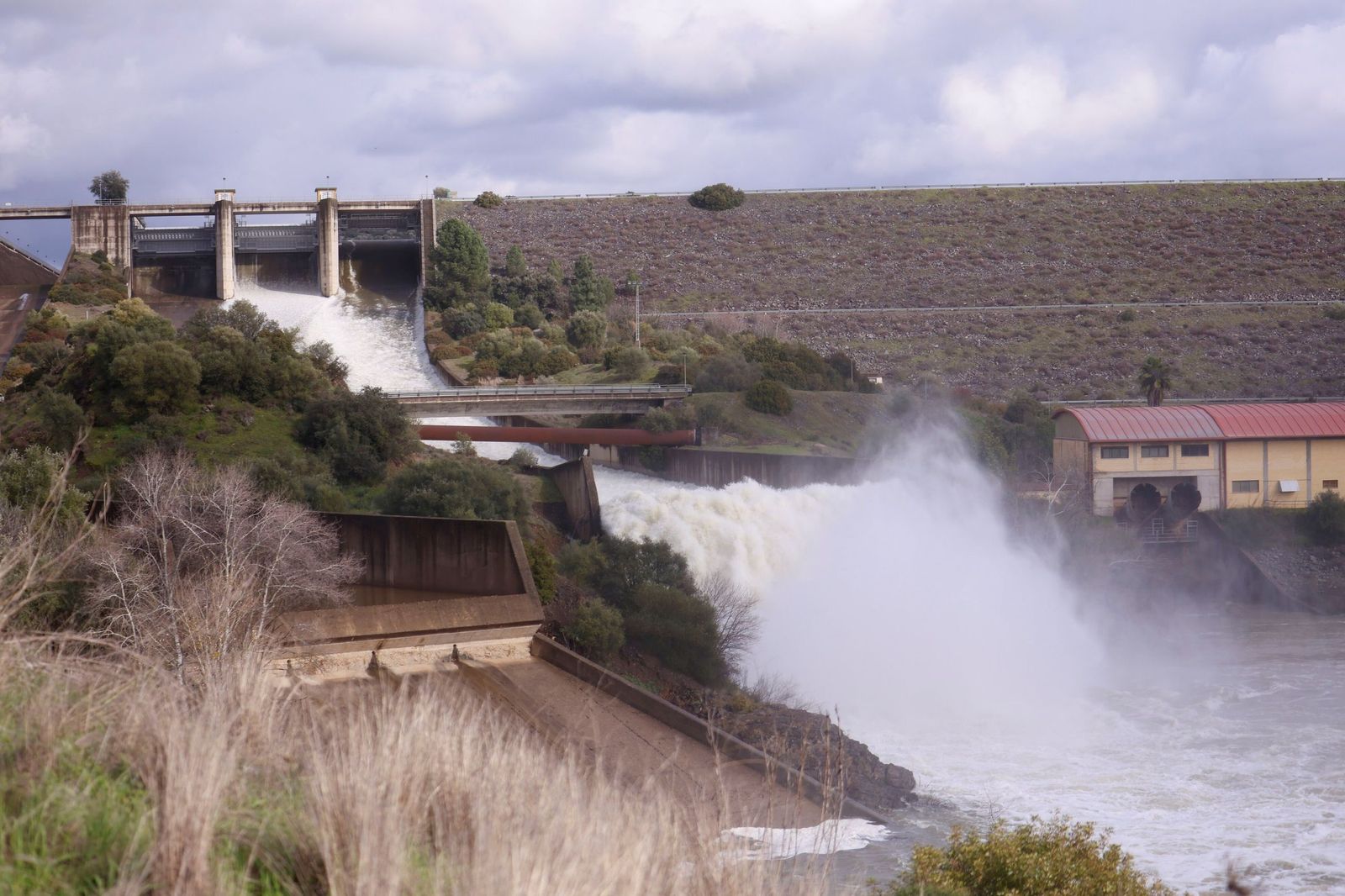La presa de San Rafael de Navallana, aliviando agua con sus compuertas abiertas.