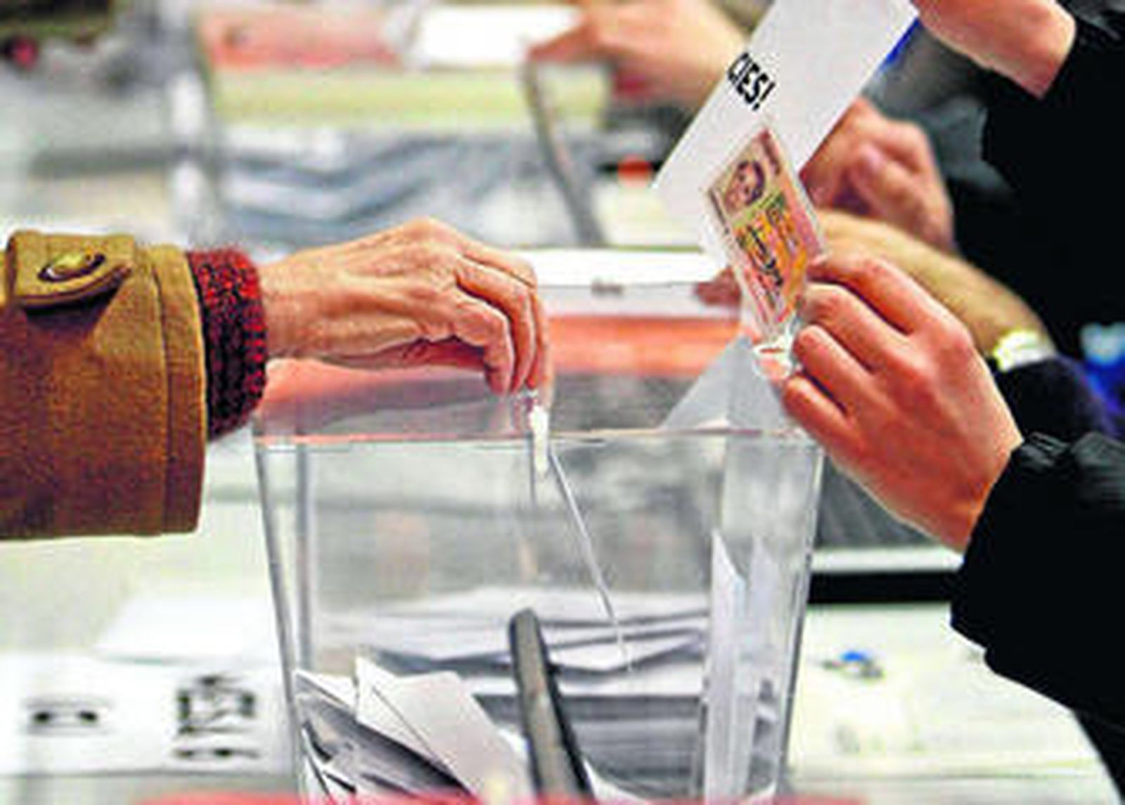 Una mujer deposita su voto en una urna.