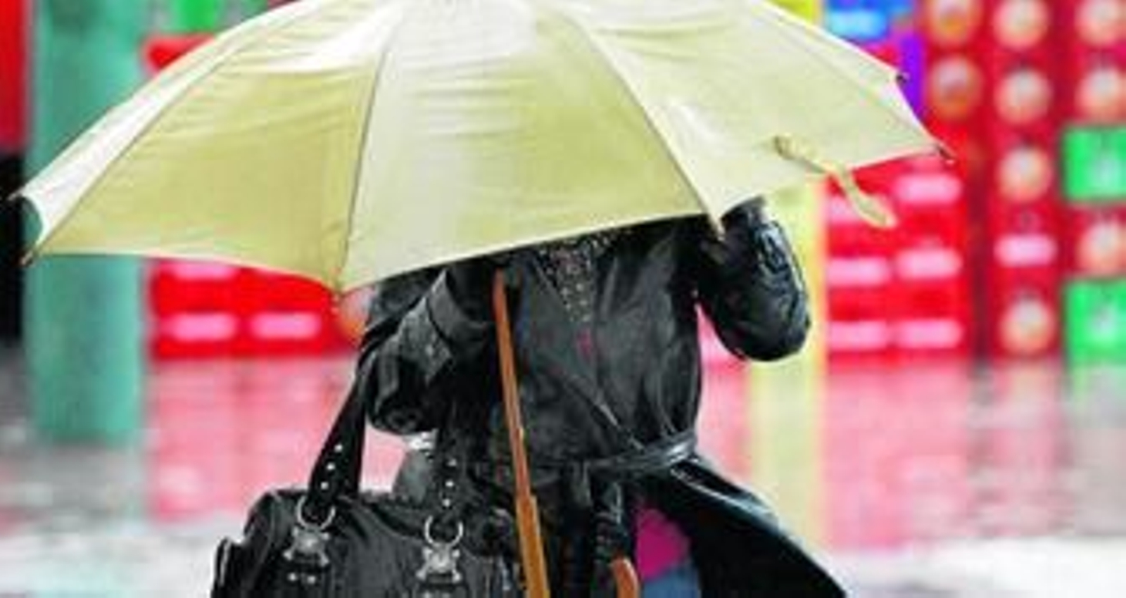 Una mujer se protege de la lluvia bajo un paraguas.