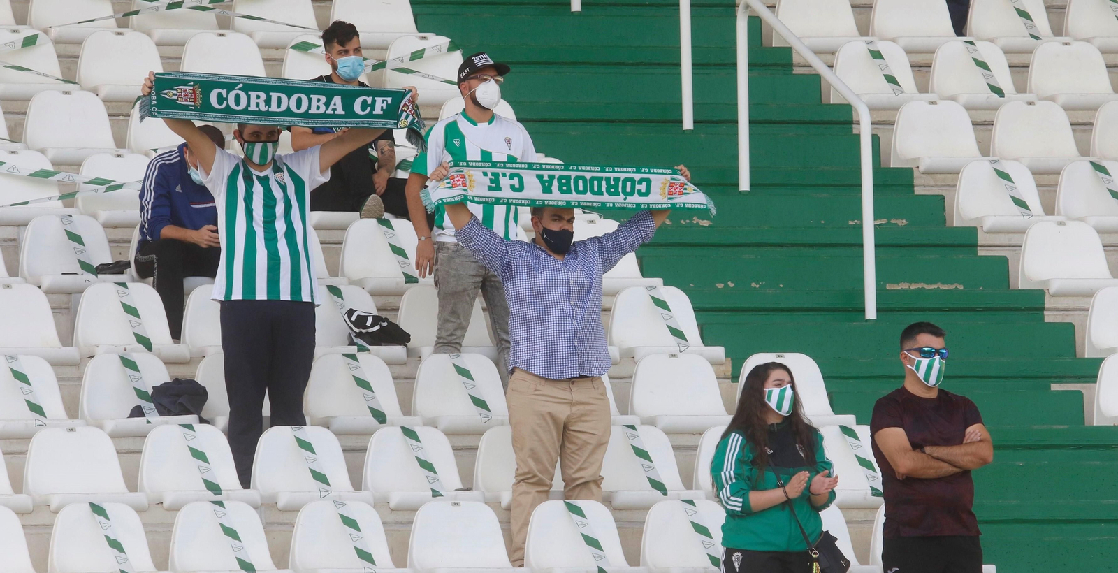 Aficionados del Córdoba CF alzan sus bufandas antes de arrancar el partido.