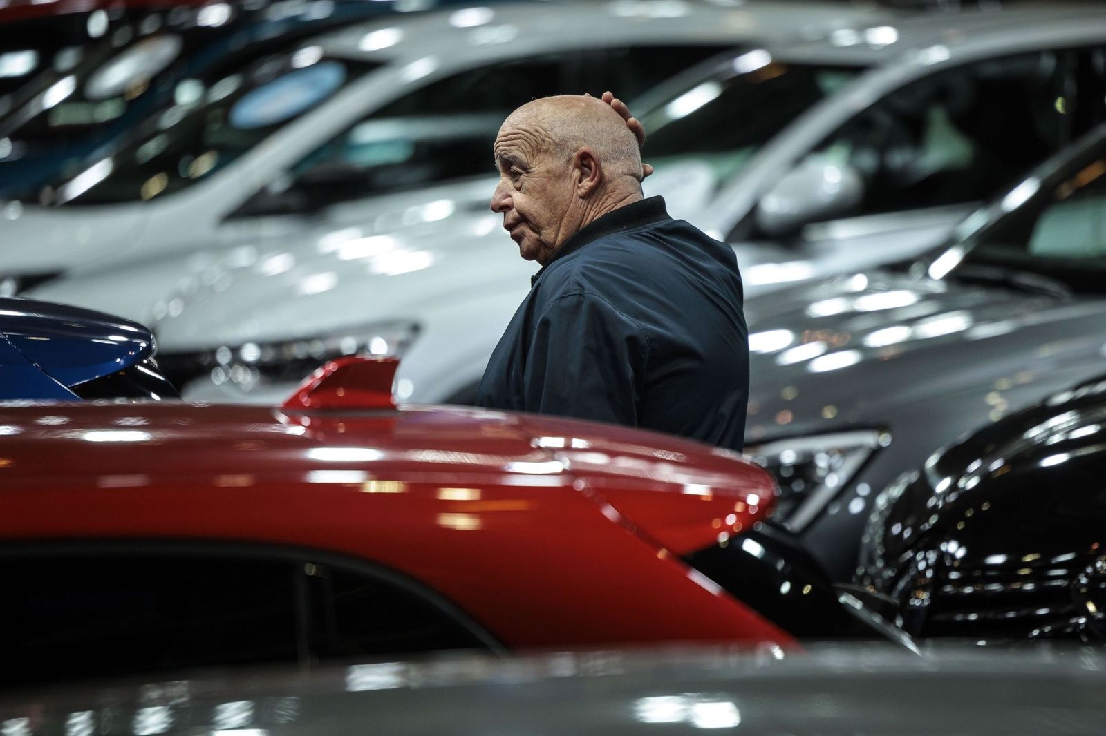 Una persona, entre decenas de automóviles, buscando hasta el último detalle para decidirse.