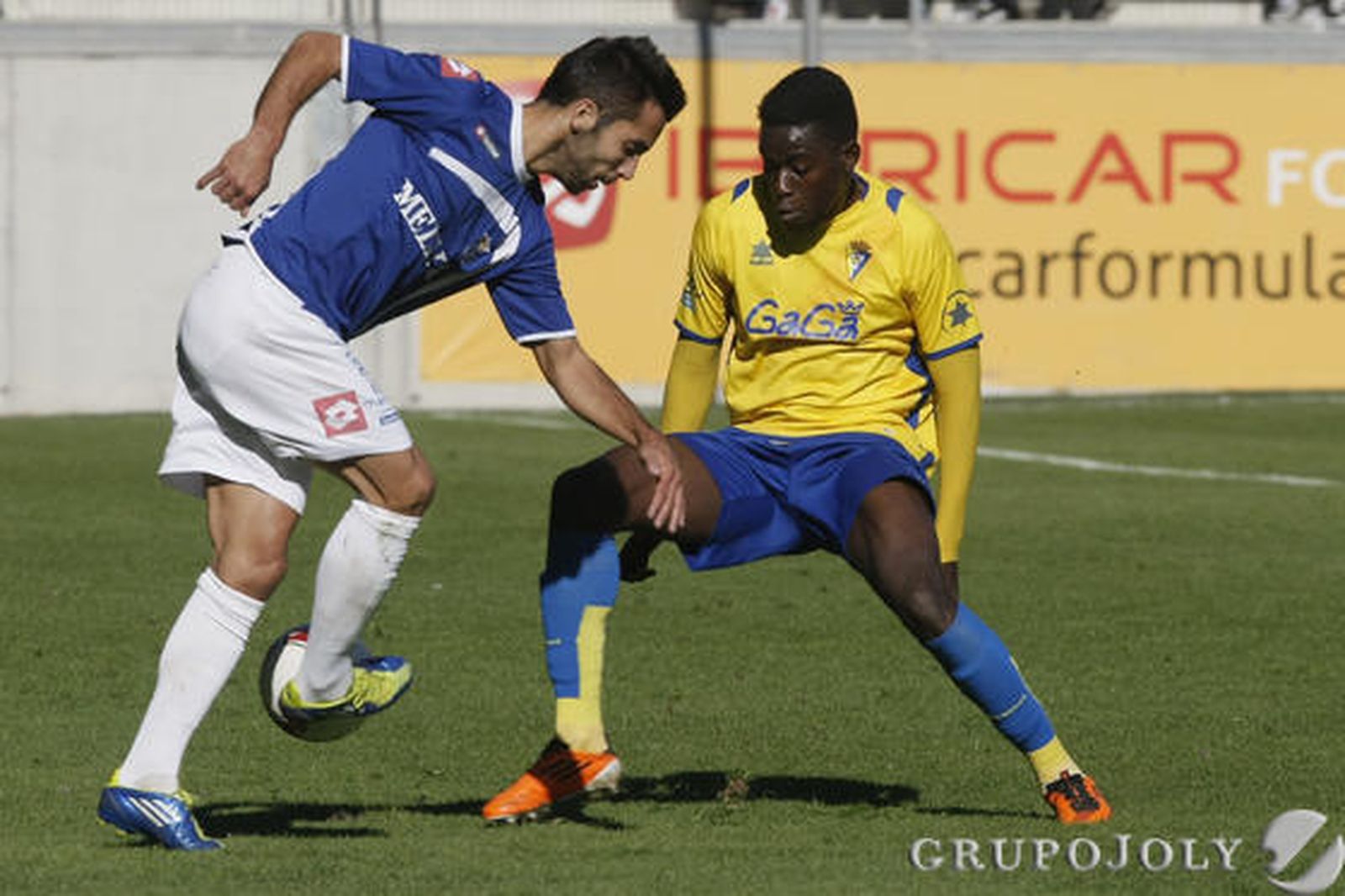 El autor del gol del Melilla, Velasco, intenta un pase ante Moke. 

Foto: Julio Gonzalez