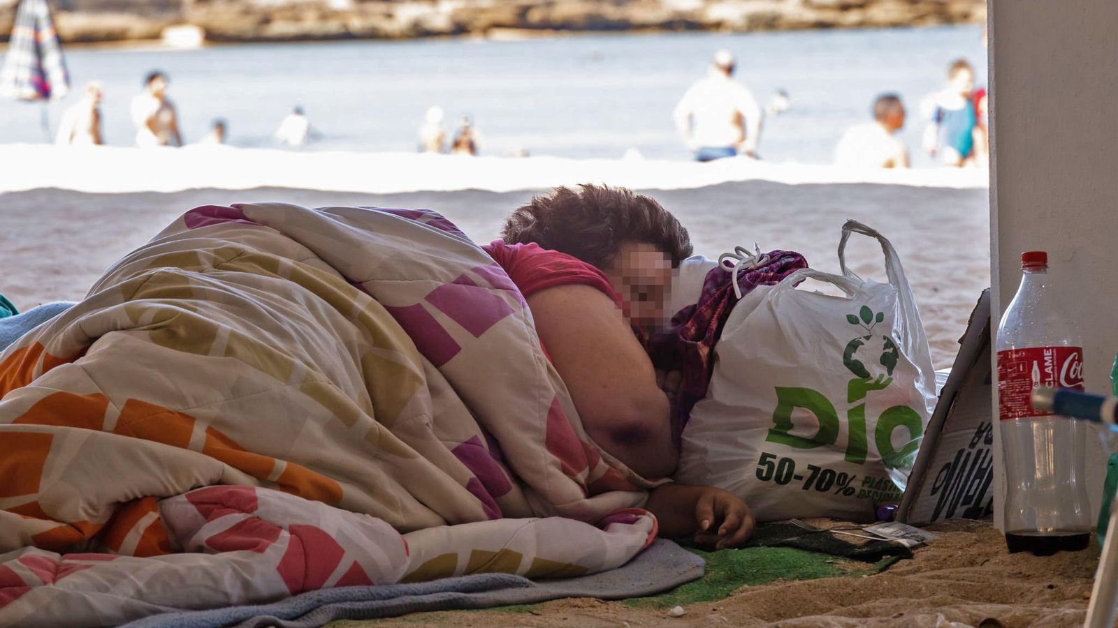 Una mujer, tapada con una manta, bajo el Balneario de la Palma, en La Caleta.
