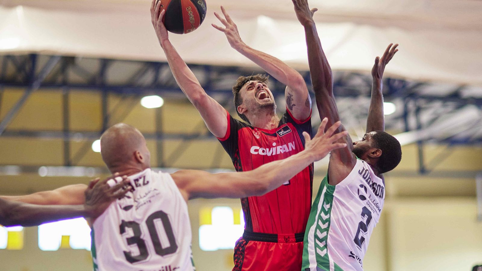 Pere Tomàs intenta anotar ante la oposición de dos jugadores del Real Betis.