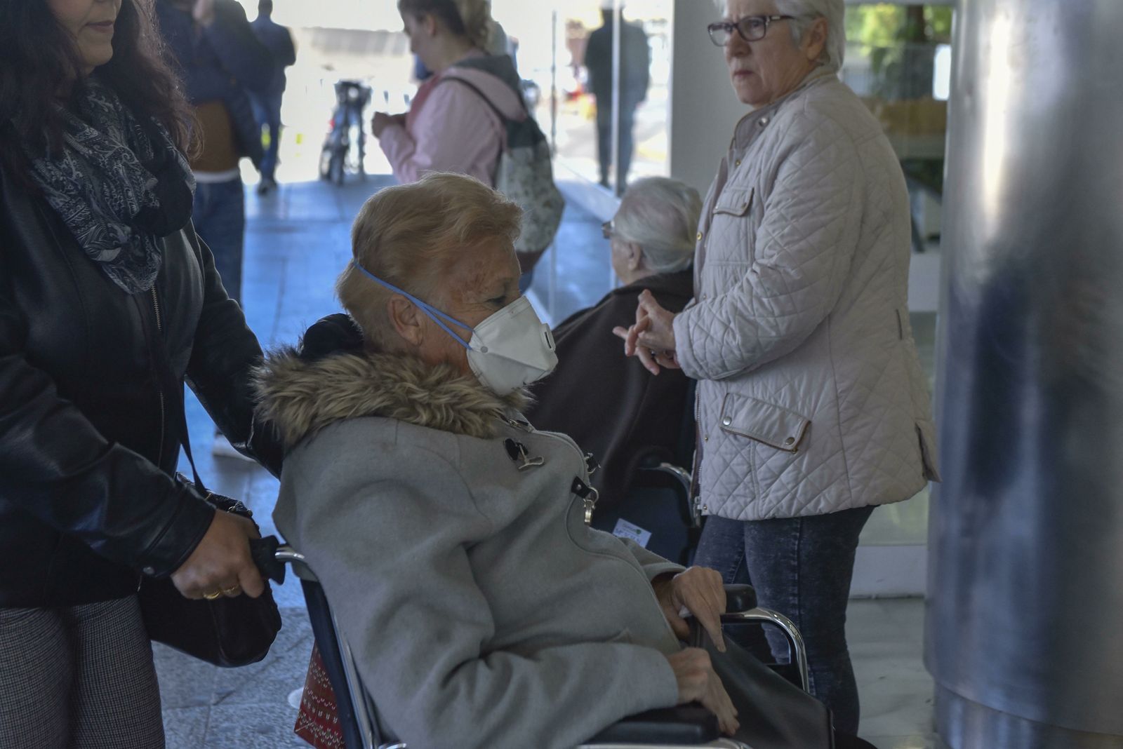 Una mujer accede a un centro hospitalario con una mascarilla.