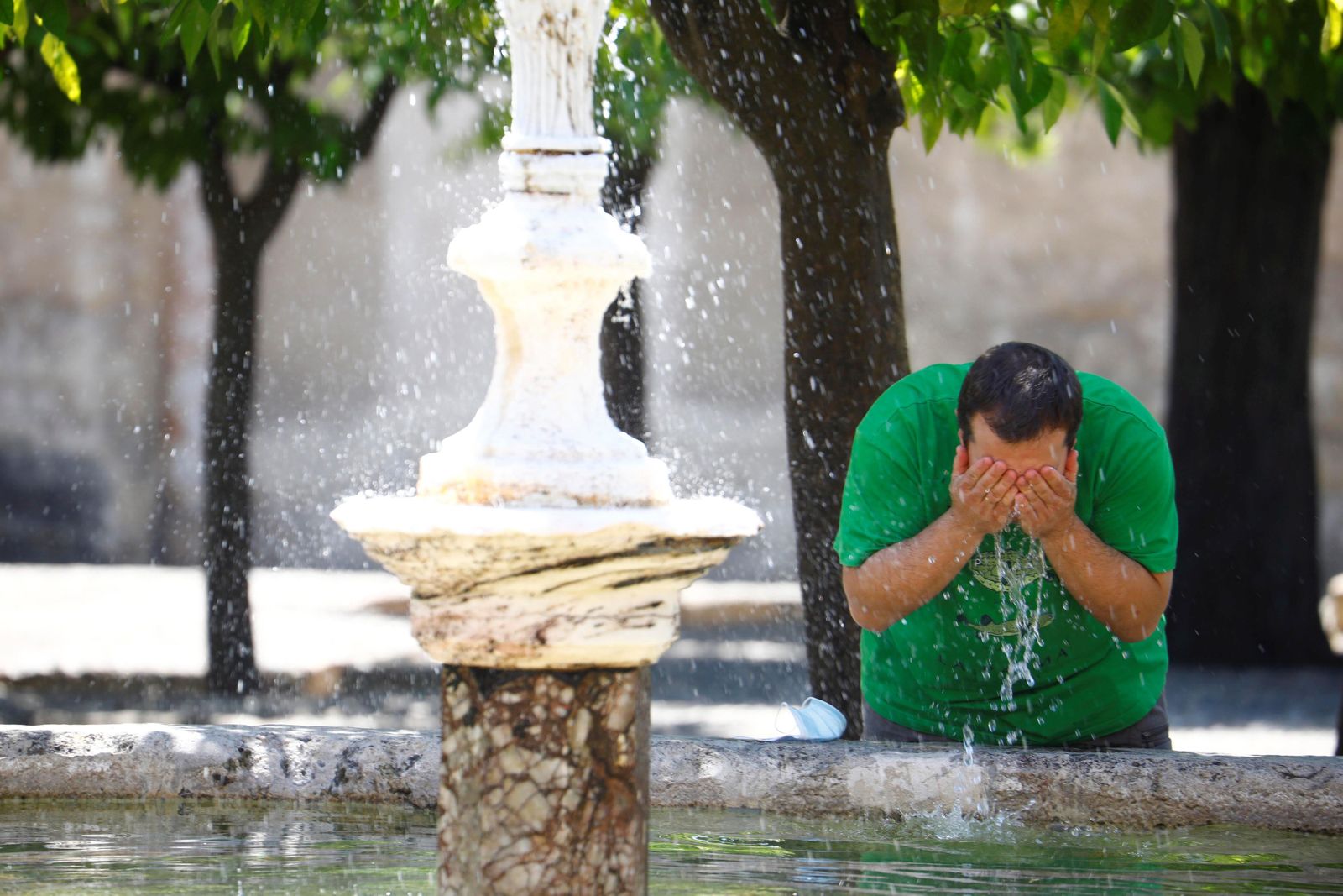 Un hombre se refresca en el Patio de los Naranjos el pasado 18 de julio en Córdoba.