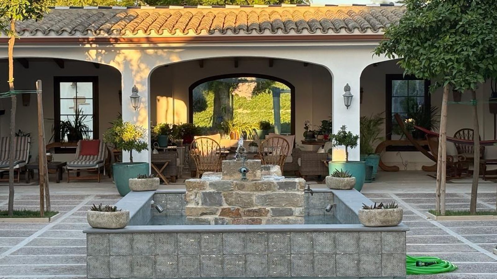 El patio, con una  fuente central con suelo de travertino y de chinos y en sus laterales de hidráulicos antiguos.