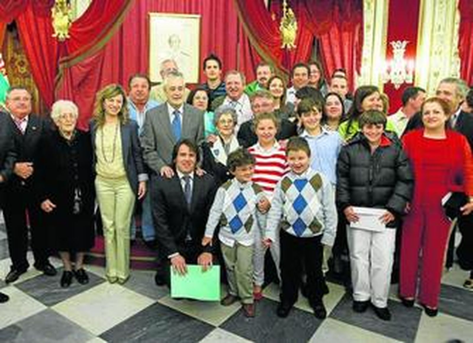 Teresa Montero, en el centro con la ministra de Igualdad, entre el presidente de la Junta y el de Diputación, rodeada por parte de su gran familia.