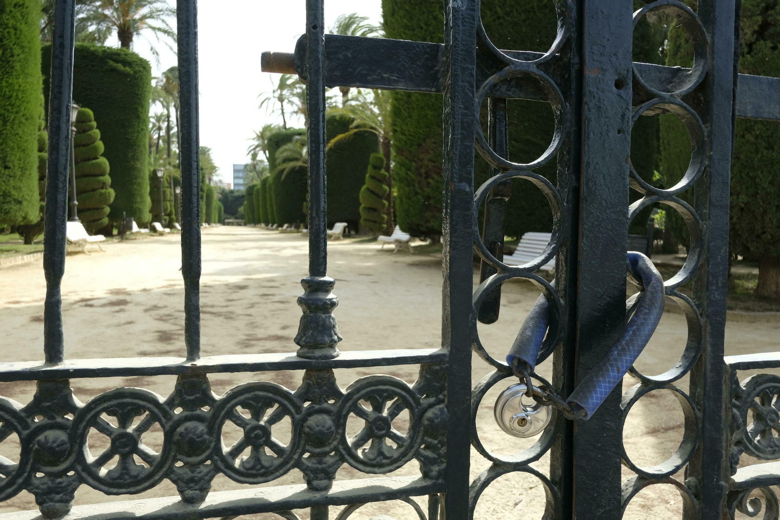 Una imagen del paseo central del Parque Genovés a través de la cancela trasera.