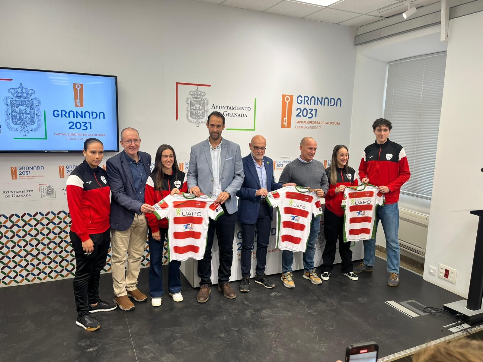 Autoridades y jugadoras del equipo posan tras la firma del acuerdo de colaboración