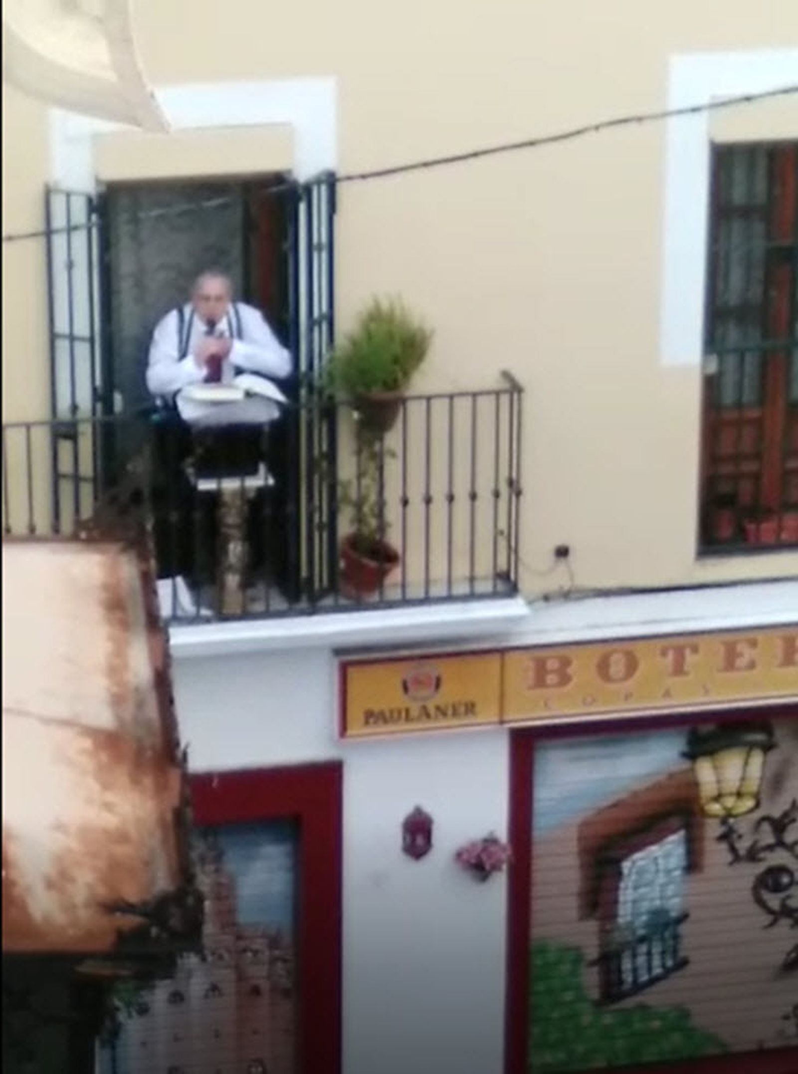 Rafael Raya Rasero leyendo el Quijote desde un balcón de la Alfalfa.