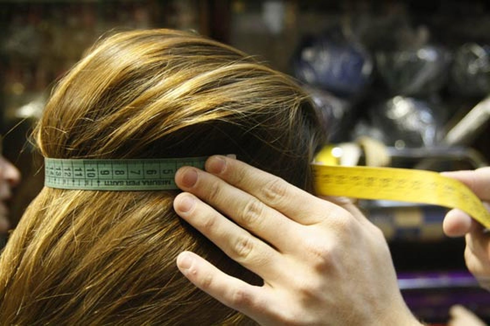 La dependienta mide las dimensiones para realizar el capirote de una clienta. 

Foto: Fco. Lorca