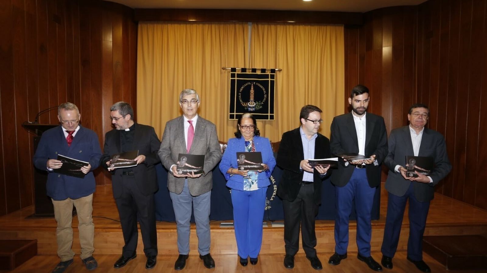 Los participantes en el acto muestran el libro editado con motivo del aniversario.