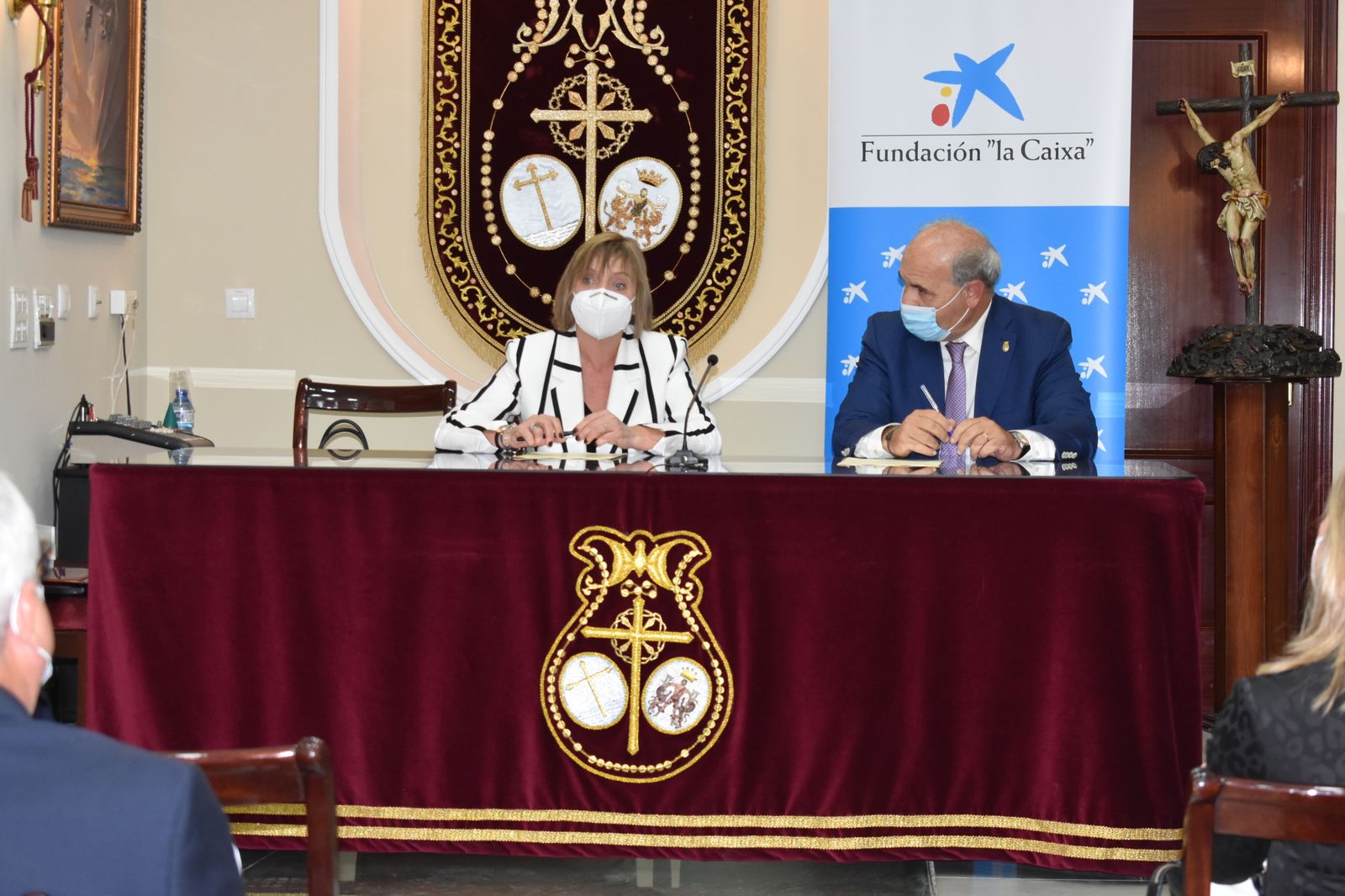 Maria Jesús Catalá, directora territorial de CaixaBank en Andalucía Occidental y Extremadura y Juan Carlos Jurado, presidente del Consejo de Hermandades y Cofradías de Cádiz, en la firma del convenio de colaboración en materia asistencial entre ambas entidades, el pasado mes de noviembre.