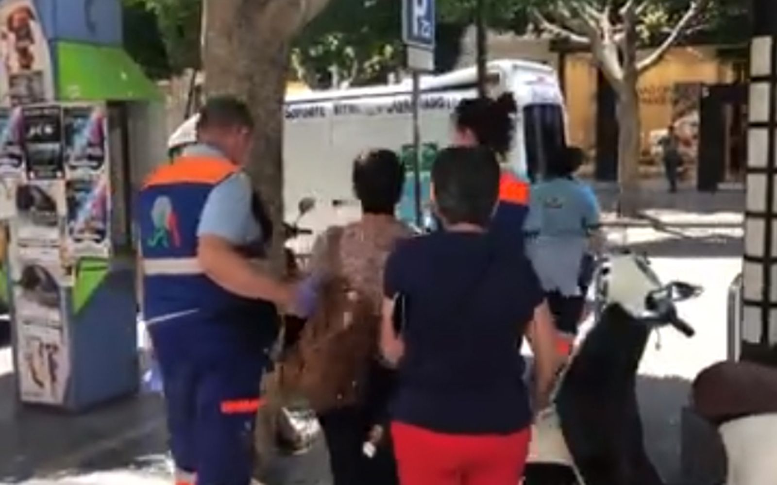 Una de las vecina encerrada se dirige a una ambulancia acompañada de personal sanitario.