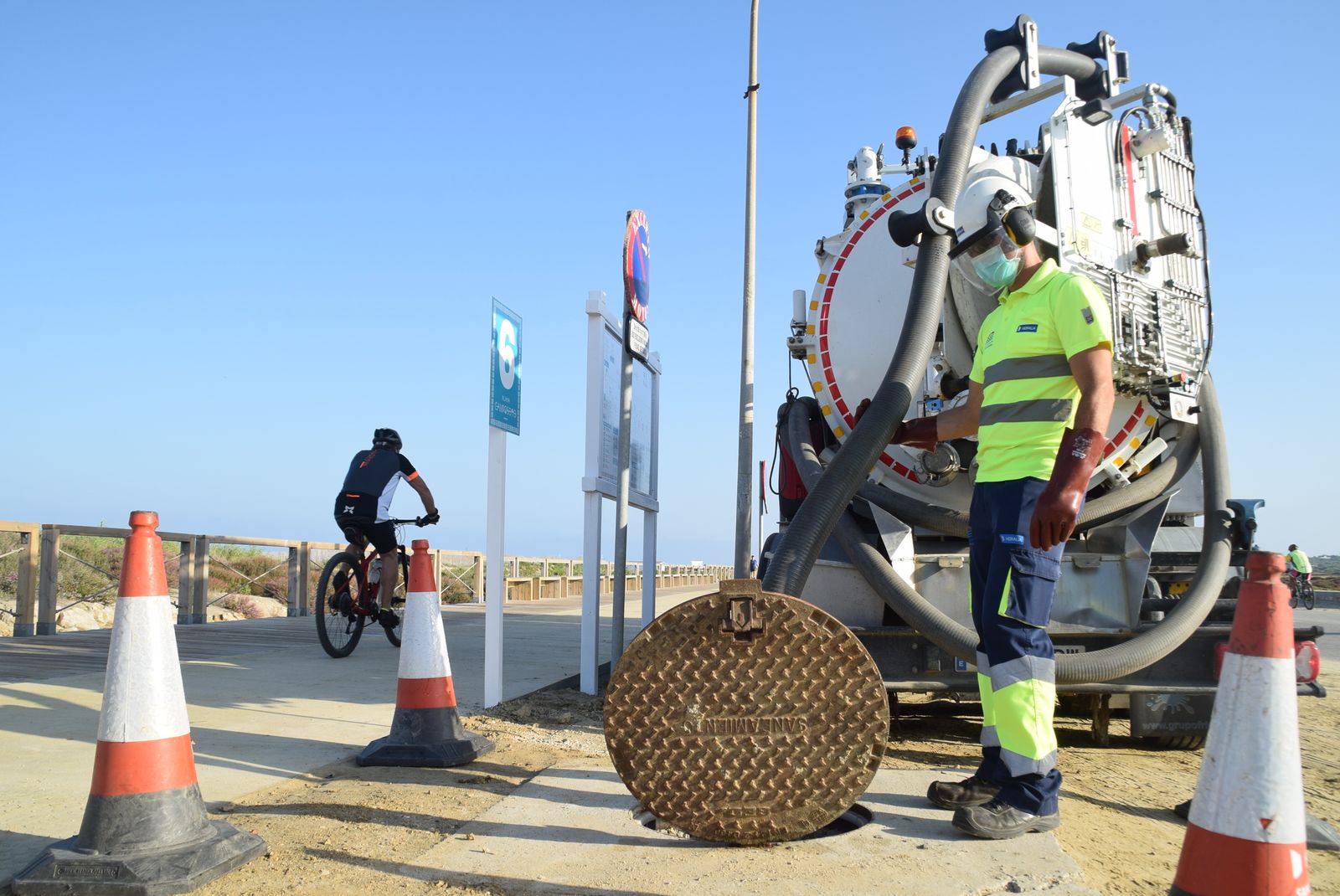 Un operario y un camión de Hidralia en una fosa séptica de la playa de Camposoto.