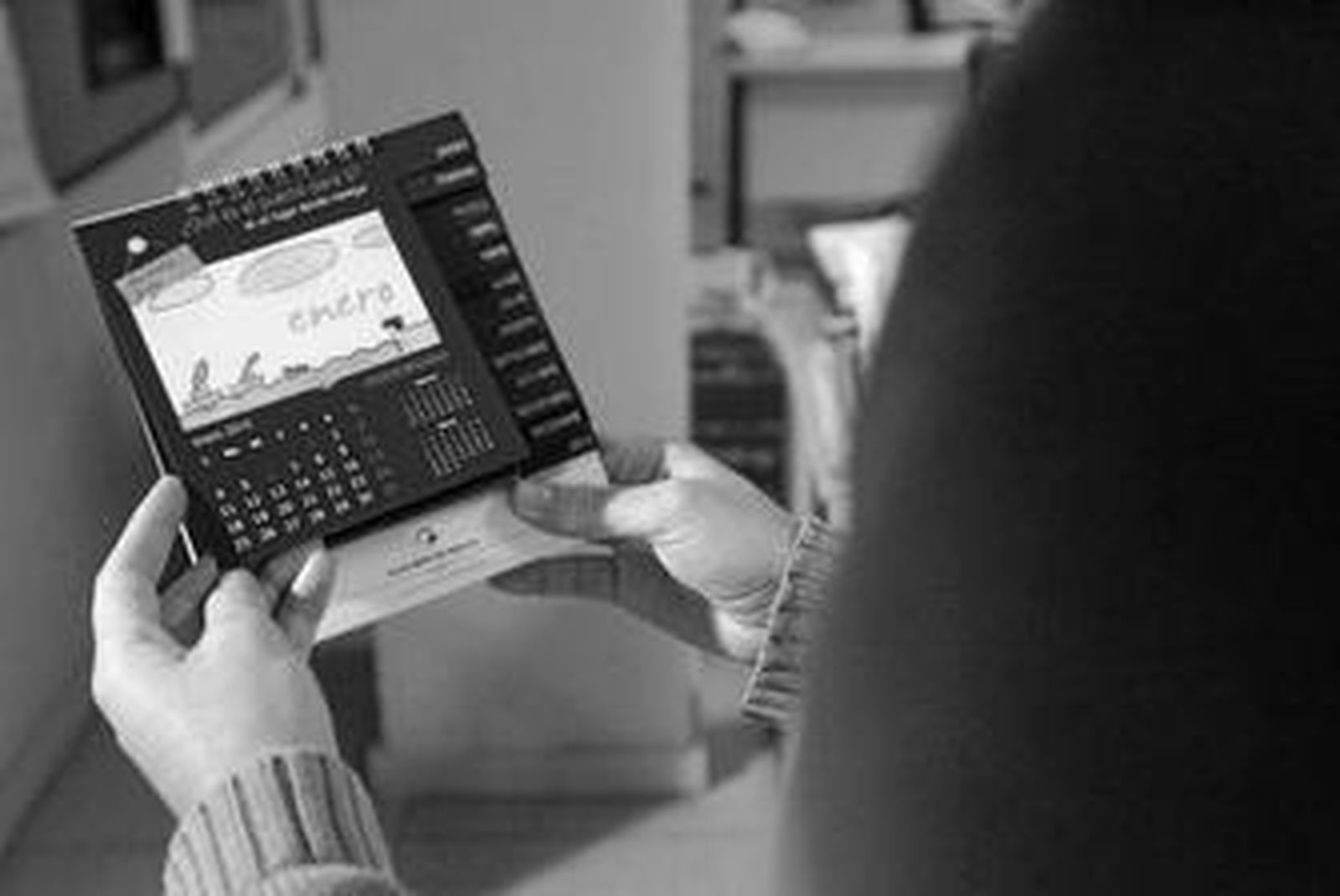 Una persona consulta el mes de enero con el calendario de la APBA.