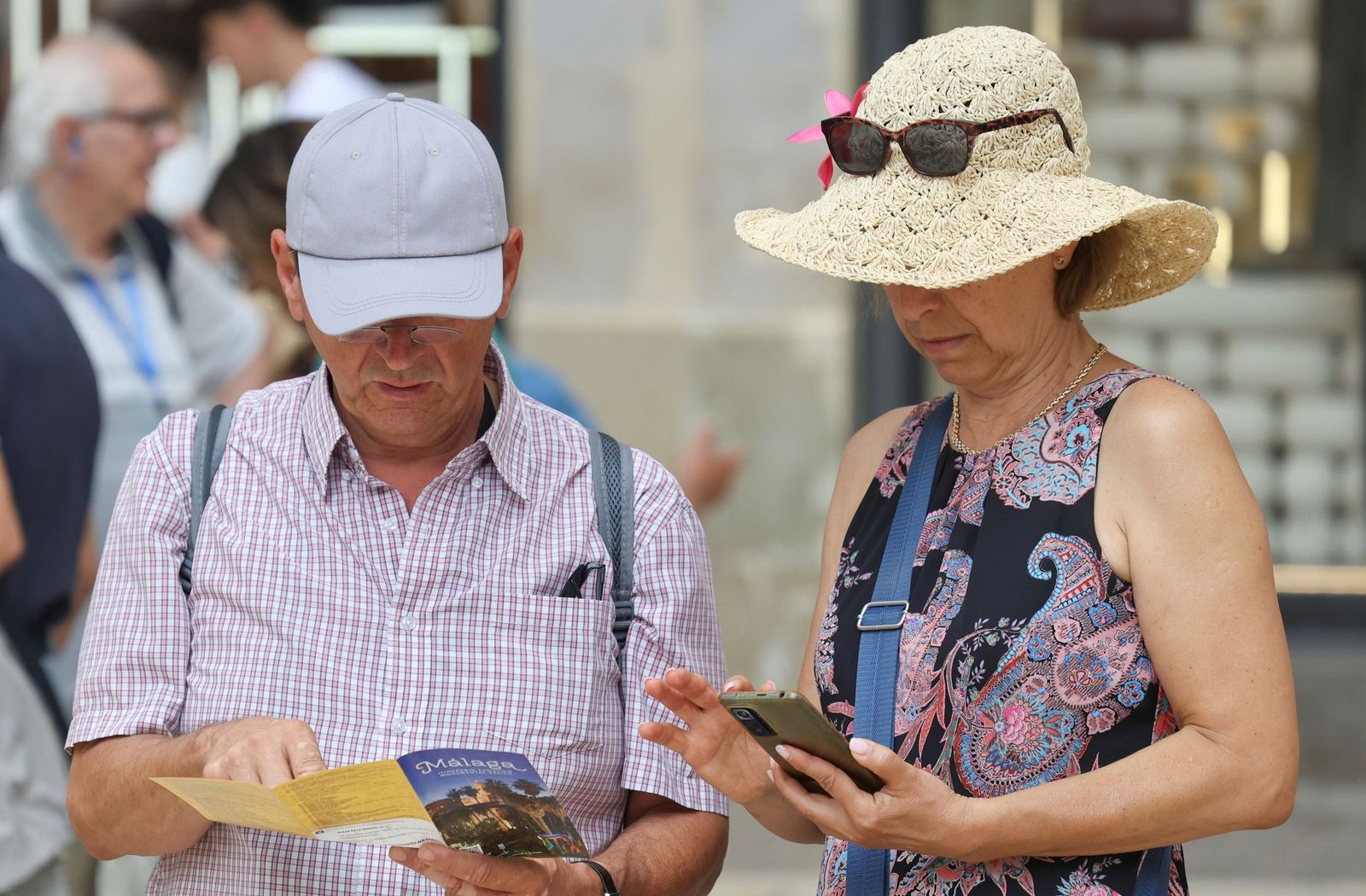 Dos turistas en Málaga mirando un folleto de la ciudad.