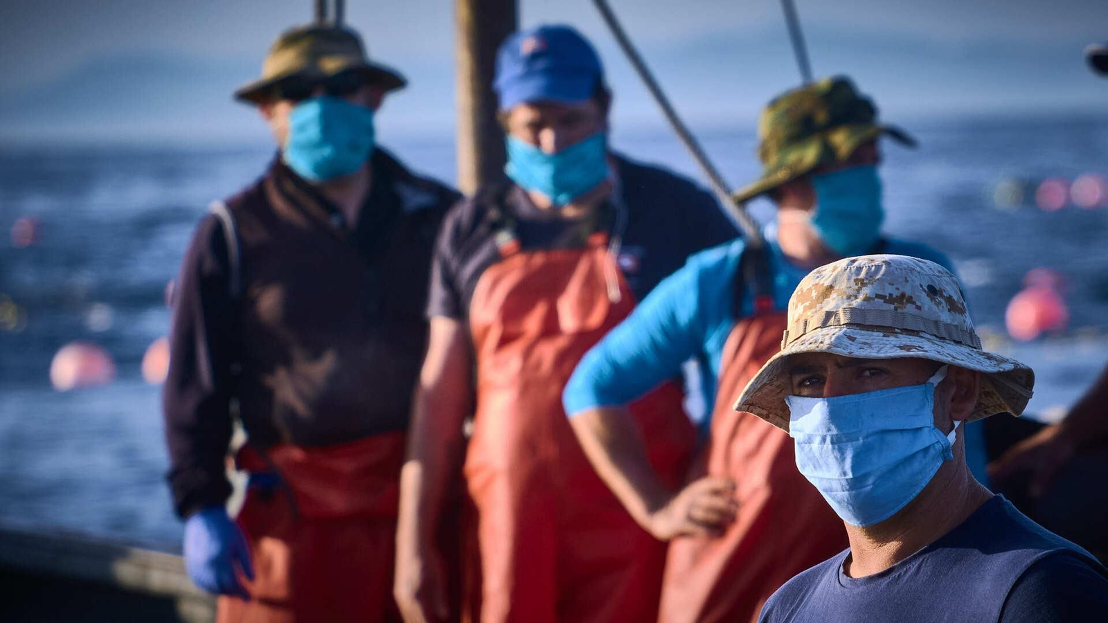 Marineros protegidos con mascarillas repartidos por varias de las embarcaciones
