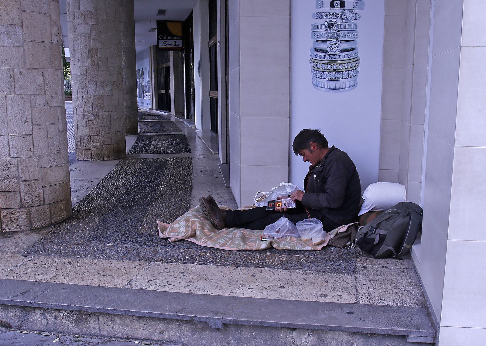 Una persona sin hogar descansa en la calle.