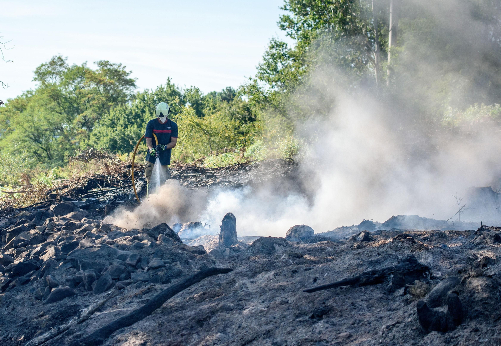 Efectivos de bomberos terminan de sofocar el incendio declarado en una zona rural cercana al monte Monforte, en Basauri (Vizcaya)
