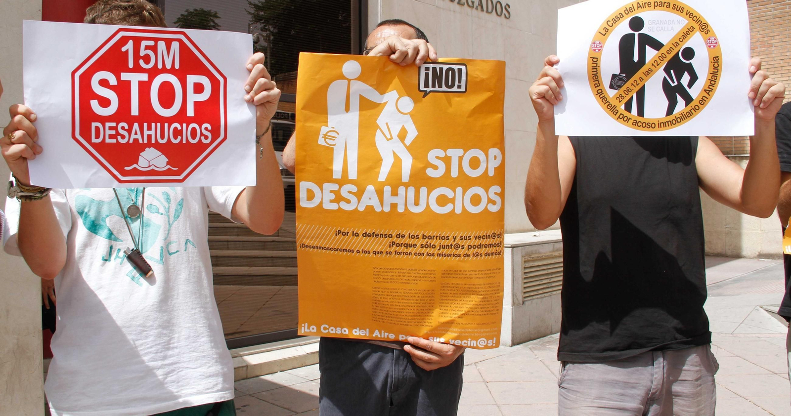 Varias personas sostienen carteles de Stop Desahucios.