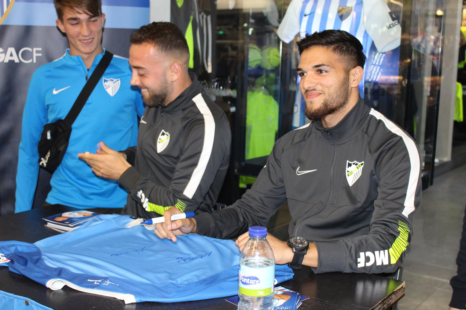 Antoñín y Keidi Bare se hacen fotos y firman a los aficionados del Málaga CF